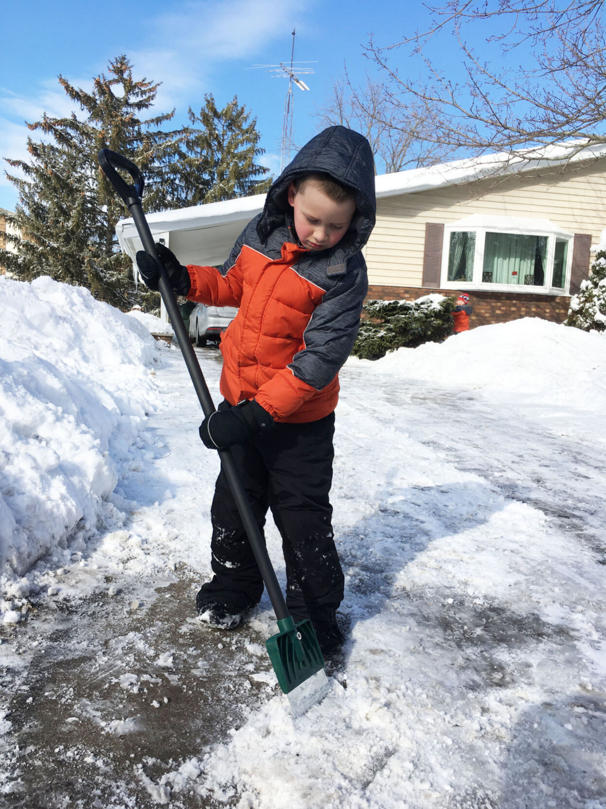 Jameson Ramon, 7, chops frozen snow in driveway in Union Grove